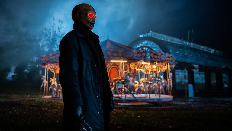 Creepy figure with heart eyes in front of carousel. Horror character. Halloween.