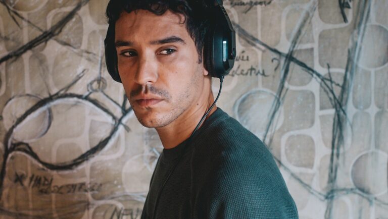 Ghost Trail movie scene. Man with headphones looks to the side. Abstract art background.