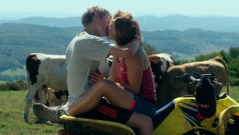 Couple kissing on ATV with cows in background. Rural romance, farm life, and countryside love.