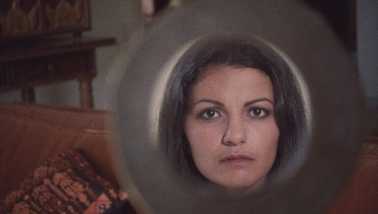 Leila, a woman's face framed in a circle, stares intently. Heiny Srour's Several Futures film still.