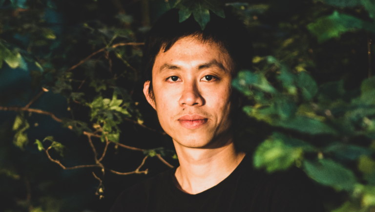 Trương Minh Quý portrait. Vietnamese filmmaker Trương Minh Quý surrounded by green foliage. Interview with Trương Minh Quý.