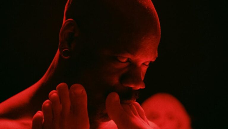 Man licking feet in red light. Erotic, sensual, and provocative art. Adult content.