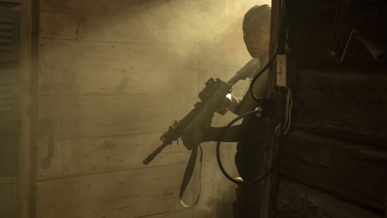 Overlook Film Fest 2025: Man with rifle in 40 Acres horror movie scene. Suspenseful, dark.