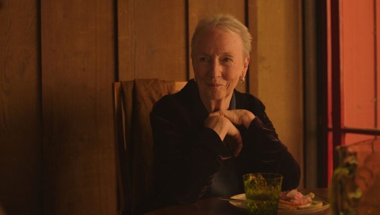 Still from Familiar Touch featuring an older woman with short gray hair at a table. Sarah Friedland film review.