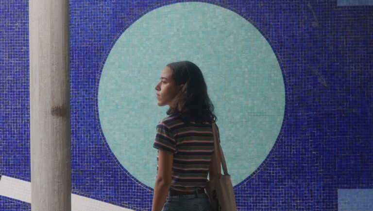 Lost Chapters film still. Woman in front of blue mosaic art. New Directors/New Films 2025 selection.