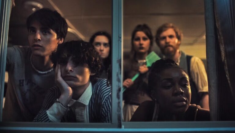 Hell of a Summer cast. Group of young adults looking out of a window, suspenseful scene. Finn Wolfhard.