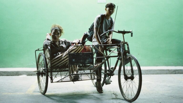 Woman in sidecar, man on bicycle taxi. Southeast Asia travel, local transportation.