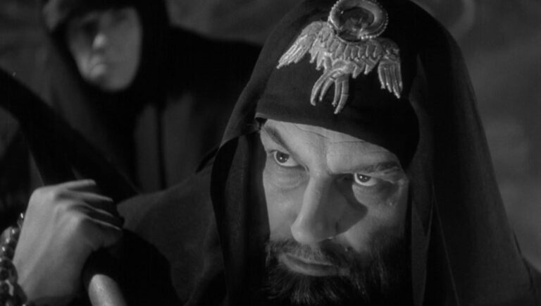 Still from *Ivan the Terrible*, Part II. A hooded, bearded man stares intensely. Revolution and Russian history.