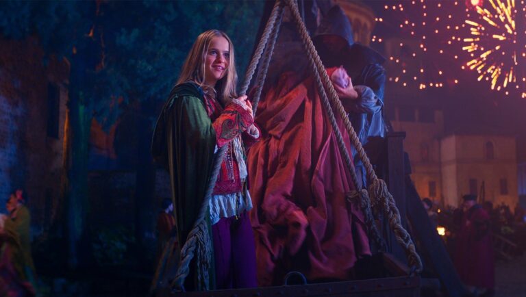 Hocus Pocus 2 scene with young witch, fireworks, and crowd. Nostalgic Halloween movie vibes.