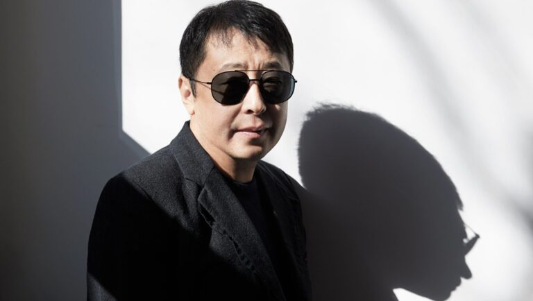 Jia Zhangke, award-winning Chinese film director, wears sunglasses and a dark jacket in a portrait. Interview with Jia Zhangke.