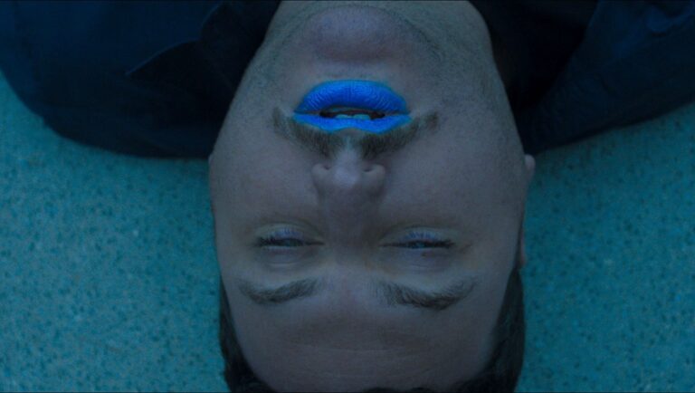 Man with blue lipstick. Portrait of a person with closed eyes and blue lips. Beauty concept.