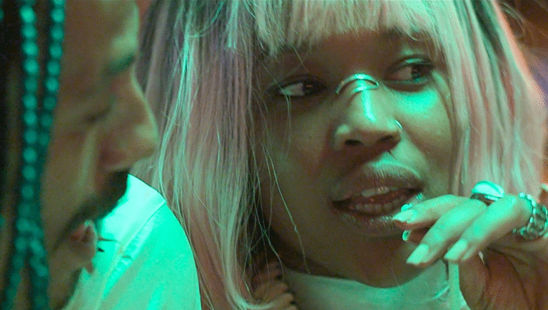 Close-up of a woman with pink hair, nose rings, and hand jewelry. Fashion.
