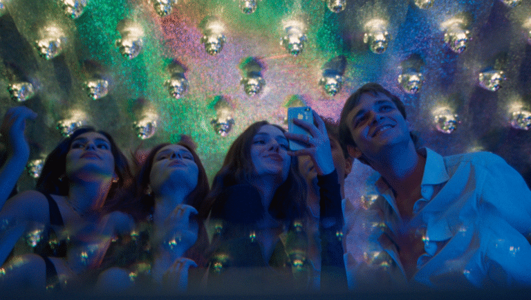 Friends taking selfie at disco party. Disco balls reflect light. Nightlife, fun.