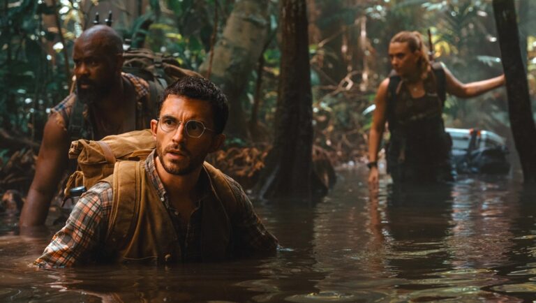Jurassic World: Rebirth movie scene. Characters wade through jungle water. Gareth Edwards film review.