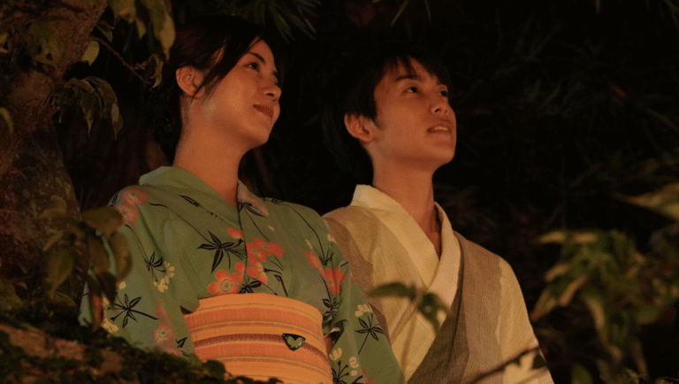 Japanese couple in yukata. Woman in floral kimono, man in traditional robe. Cultural attire, looking up.
