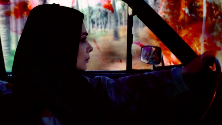 Film still from FIDMarseille 2025, Night Flowers: Woman driving car at night, forest background.