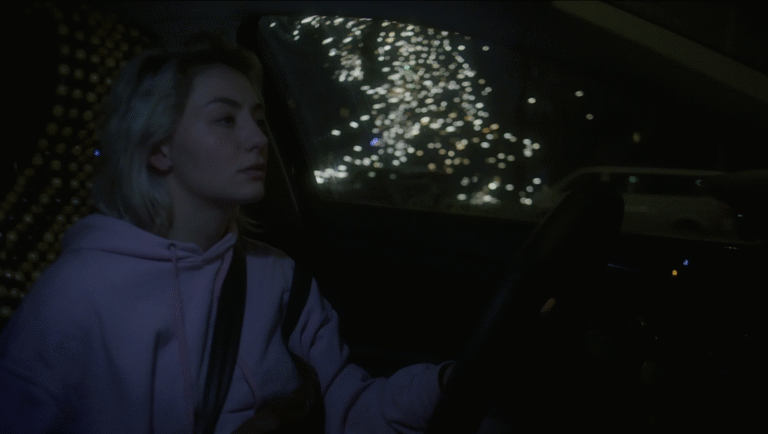 FIDMarseille 2025 film still: Woman driving at night, headlights blur. Copper, Headlights, Morlaix film scene.