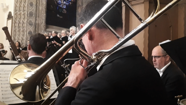 FIDMarseille 2025 film still: Trombone player in orchestra with choir. Requiem film.