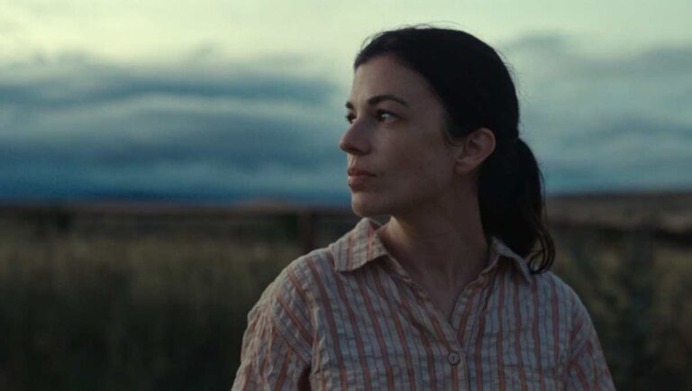 Andrea Riseborough in Here Before movie. Woman looking to the side in an outdoor setting. Film still.