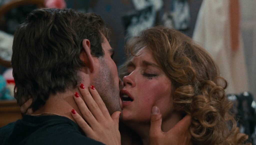 Romantic embrace. Close-up of a passionate kiss between a man and a woman. Curly hair, red nails.