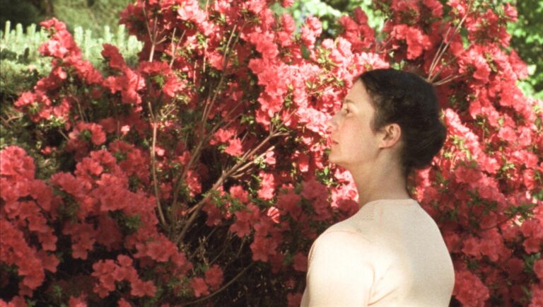FIDMarseille film still: Woman gazes at red azalea bush. Thousand Waves film image.