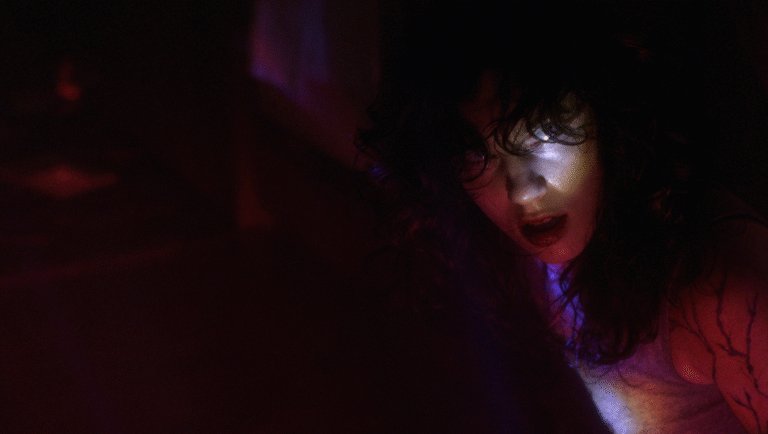 Hellcat film still from Fantasia Fest 2025. Woman in dark, red lighting. Horror movie scene.