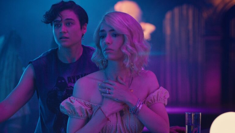 Sham movie still from Fantasia Fest 2025. Two women in a bar, bathed in neon blue and pink lights.