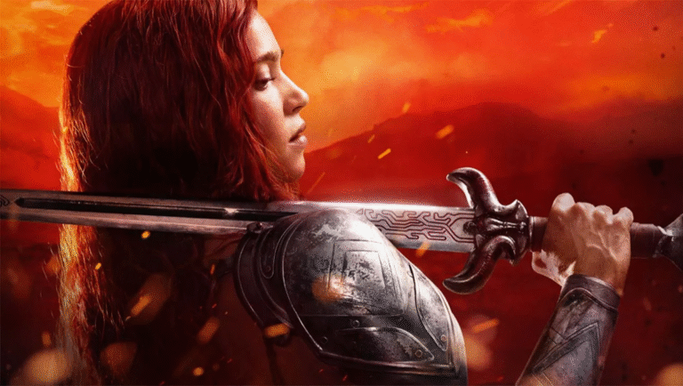 Red Sonja publicity still. Red-haired warrior with sword and armor on red background.