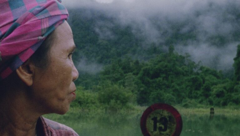 Woman with headscarf looks at misty green mountains. Rural landscape. Nature travel.