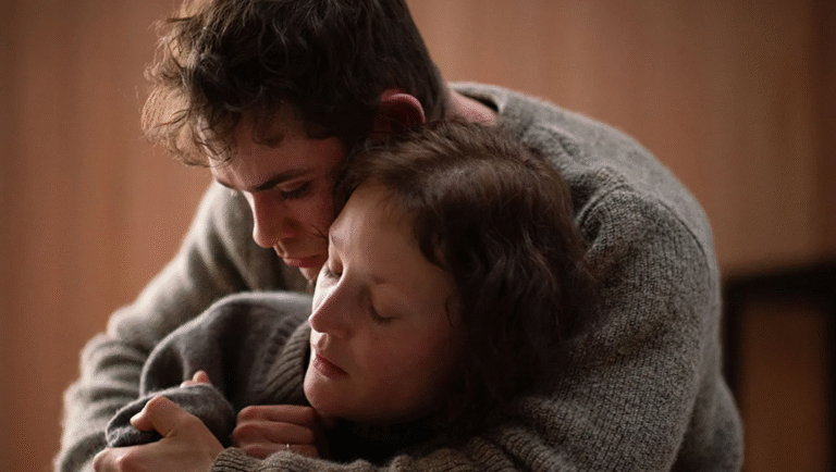 Couple embracing. Man hugs woman wearing gray sweater. Intimate moment. Wuthering Heights film.